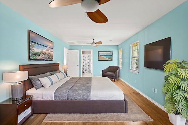 703 Amy Cir, Marble Falls, TX 78654 - bedroom with wood finished floors, ceiling fan, and connected bathroom