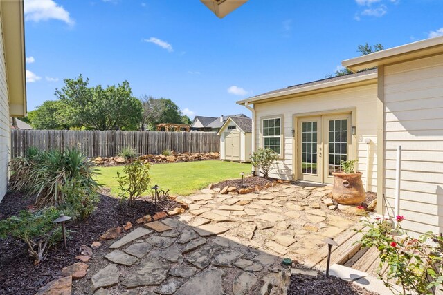703 Amy Cir, Marble Falls, TX 78654 - fenced backyard featuring french doors, a storage unit, and a patio