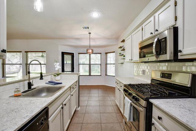 1119 Brinkley Dr, Cedar Park, TX 78613 - kitchen featuring stainless steel appliances, tasteful backsplash, white cabinets, pendant lighting, and recessed lighting