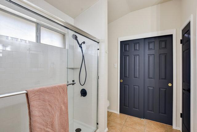 1119 Brinkley Dr, Cedar Park, TX 78613 - bathroom featuring a shower stall, lofted ceiling, and tile patterned flooring