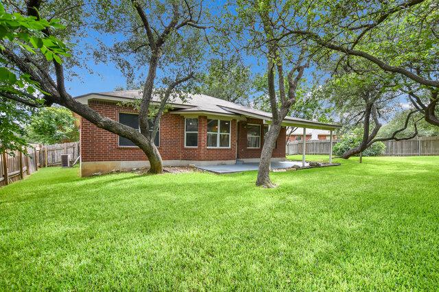 1119 Brinkley Dr, Cedar Park, TX 78613 - rear view of house with brick siding, a patio, and a fenced backyard