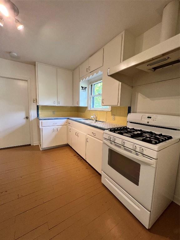 1511 Romeria Dr, Austin, TX 78757 - kitchen with gas range gas stove, range hood, white cabinetry, and light wood-style flooring