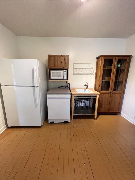 1511 Romeria Dr, Austin, TX 78757 - kitchen featuring freestanding refrigerator, built in microwave, dishwasher, light wood-style floors, and brown cabinetry