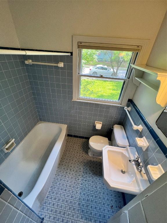 1511 Romeria Dr, Austin, TX 78757 - bathroom with tile walls, a tub, and a wainscoted wall