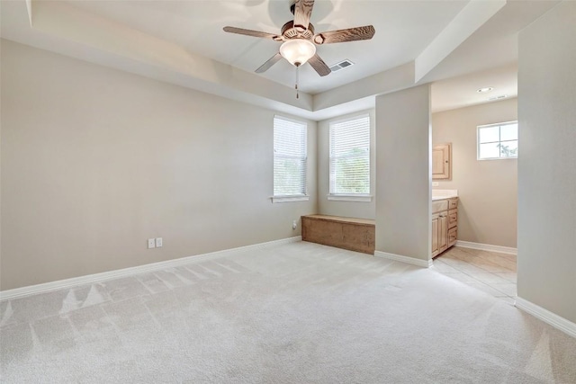 25 Meadows End Dr, Georgetown, TX 78628 - unfurnished bedroom with light carpet, a raised ceiling, ensuite bath, and ceiling fan
