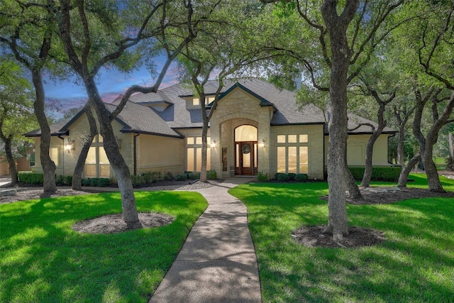 25 Meadows End Dr, Georgetown, TX 78628 - french country home featuring stone siding, a front yard, and roof with shingles