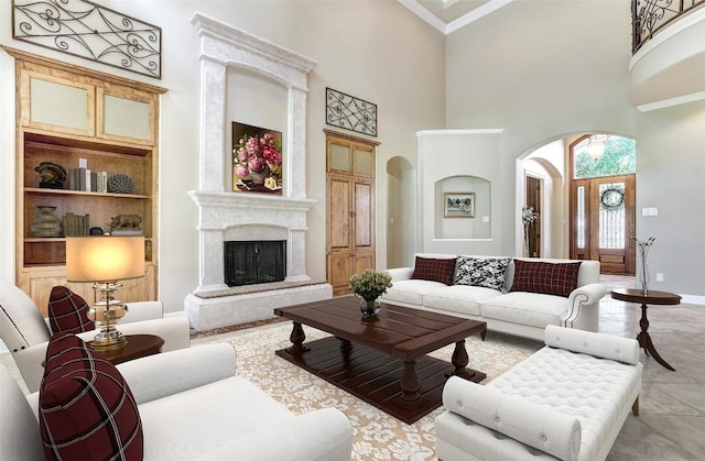 25 Meadows End Dr, Georgetown, TX 78628 - living room with arched walkways, a towering ceiling, built in shelves, a premium fireplace, and ornamental molding