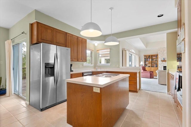 124 Hurst Creek Rd, Austin, TX 78734 - kitchen with appliances with stainless steel finishes, light countertops, brown cabinets, a center island, and a large fireplace