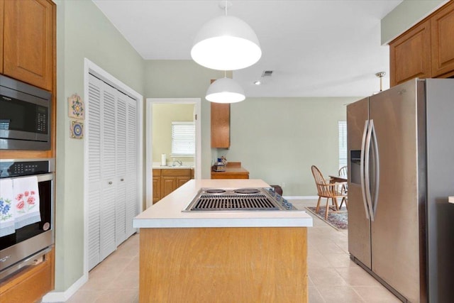 124 Hurst Creek Rd, Austin, TX 78734 - kitchen featuring appliances with stainless steel finishes, light tile patterned floors, a center island, and light countertops