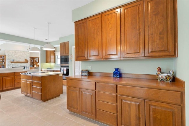 124 Hurst Creek Rd, Austin, TX 78734 - kitchen with brown cabinetry, light tile patterned floors, oven, a center island, and decorative light fixtures