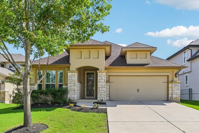 3213 Venezia Vw, Leander, TX 78641 - view of front facade featuring stone siding, an attached garage, a front yard, concrete driveway, and a shingled roof