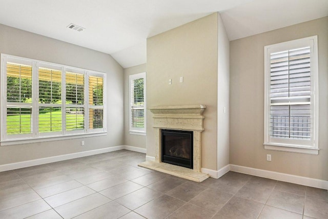 3213 Venezia Vw, Leander, TX 78641 - unfurnished living room featuring a glass covered fireplace, tile patterned flooring, and lofted ceiling