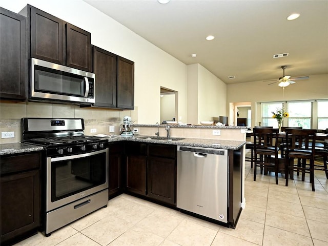 4811 Portillo Way, Pflugerville, TX 78660 - kitchen featuring stainless steel appliances, a ceiling fan, a peninsula, light tile patterned floors, and recessed lighting