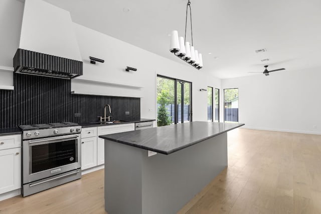 501 E 50th St, Austin, TX 78751 - kitchen featuring stainless steel appliances, white cabinets, a center island, light wood-style floors, and a ceiling fan