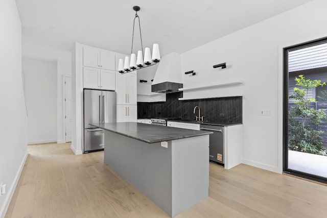 501 E 50th St, Austin, TX 78751 - kitchen with stainless steel appliances, custom range hood, decorative backsplash, and light wood-type flooring