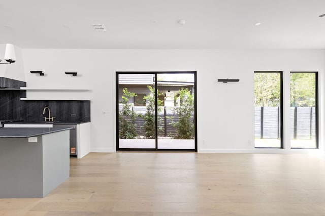 501 E 50th St, Austin, TX 78751 - kitchen with dark countertops, plenty of natural light, light wood-style flooring, and decorative backsplash