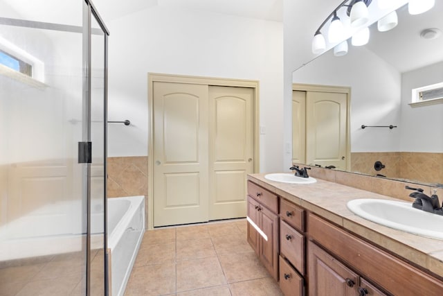 325 Swenson Dr, Hutto, TX 78634 - bathroom featuring a stall shower, double vanity, vaulted ceiling, tile patterned flooring, and a bathtub