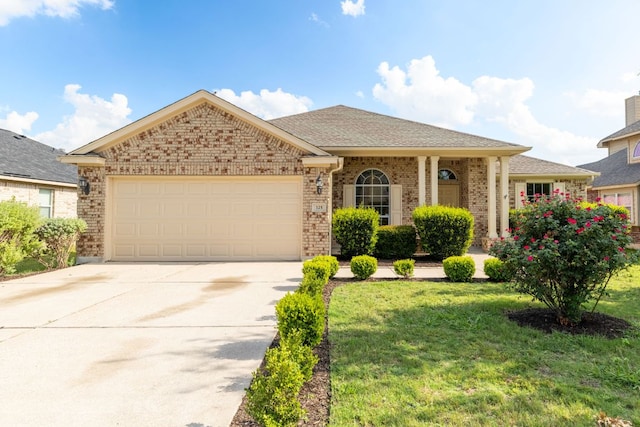 325 Swenson Dr, Hutto, TX 78634 - view of front facade with brick siding, a front lawn, a garage, and concrete driveway