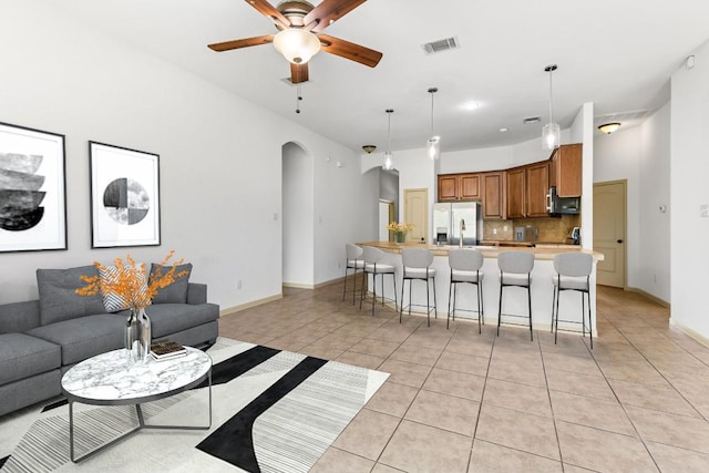 325 Swenson Dr, Hutto, TX 78634 - living area with arched walkways, light tile patterned flooring, and a ceiling fan