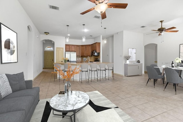 325 Swenson Dr, Hutto, TX 78634 - living room featuring a ceiling fan, arched walkways, and light tile patterned flooring