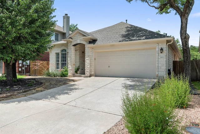4608 Hibiscus Valley Dr, Austin, TX 78739 - view of front facade featuring stone siding, an attached garage, a shingled roof, and driveway