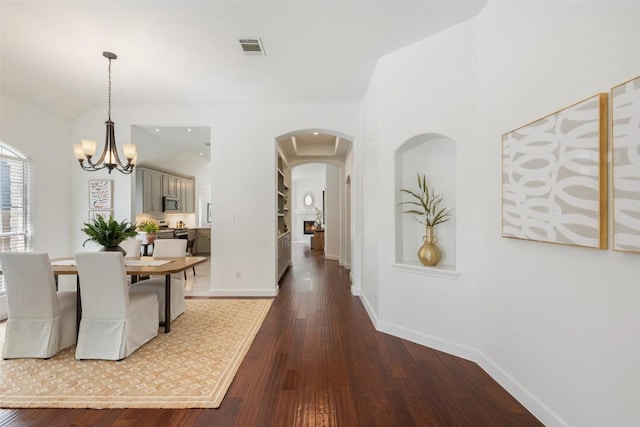 4608 Hibiscus Valley Dr, Austin, TX 78739 - unfurnished dining area with arched walkways, dark wood-type flooring, and a chandelier