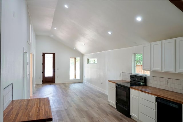 545 W Vaughan St, Bertram, TX 78605 - kitchen featuring black appliances, butcher block counters, vaulted ceiling, plenty of natural light, and white cabinetry