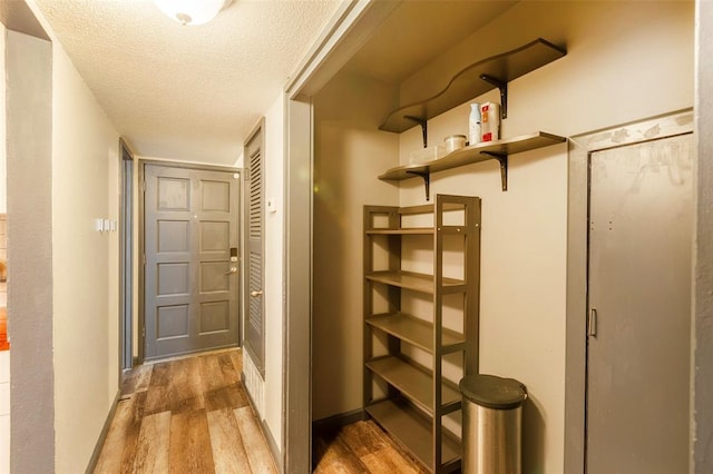 3431 N Hills Dr Unit 115, Austin, TX 78731 - doorway to outside with wood finished floors and a textured ceiling