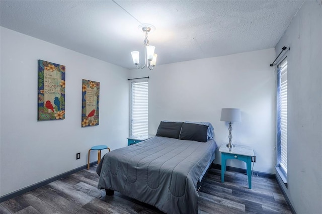 3431 N Hills Dr Unit 115, Austin, TX 78731 - bedroom with wood finished floors, multiple windows, a chandelier, and a textured ceiling