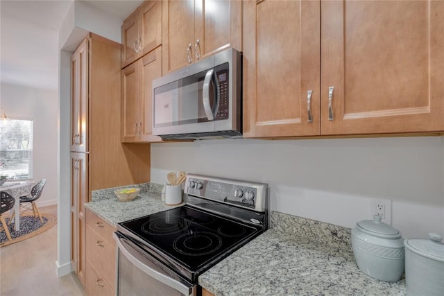 12166 Metric Blvd Unit 103, Austin, TX 78758 - kitchen with stainless steel appliances, light stone counters, and light brown cabinetry