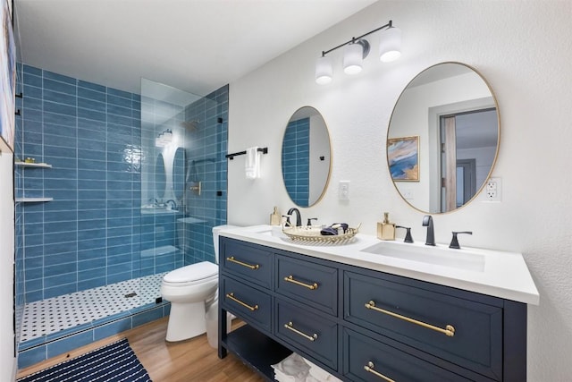 1211 S Church St, Georgetown, TX 78626 - full bathroom featuring double vanity, a tile shower, and wood finished floors