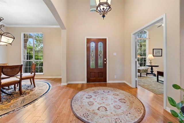 9920 Michelle Hl, Garden Ridge, TX 78266 - foyer with healthy amount of natural light, light wood-style floors, arched walkways, crown molding, and a high ceiling