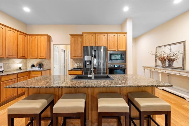 9920 Michelle Hl, Garden Ridge, TX 78266 - kitchen featuring appliances with stainless steel finishes, backsplash, a breakfast bar area, and recessed lighting