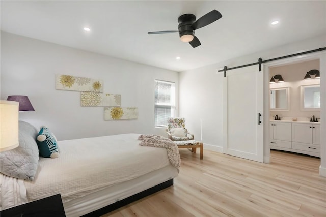 10410 Quail Ridge Dr, Austin, TX 78758 - bedroom with a barn door, light wood-type flooring, connected bathroom, recessed lighting, and a ceiling fan