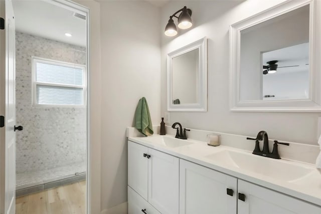 10410 Quail Ridge Dr, Austin, TX 78758 - full bath featuring double vanity, a tile shower, and wood finished floors