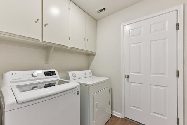906 Jasmine Trl, Georgetown, TX 78626 - laundry area with separate washer and dryer, cabinet space, and wood finished floors