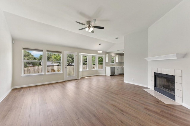 906 Jasmine Trl, Georgetown, TX 78626 - unfurnished living room featuring vaulted ceiling, a ceiling fan, a fireplace, and wood finished floors