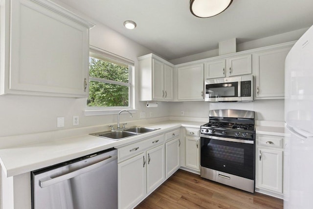 906 Jasmine Trl, Georgetown, TX 78626 - kitchen with appliances with stainless steel finishes, white cabinetry, light countertops, and wood finished floors
