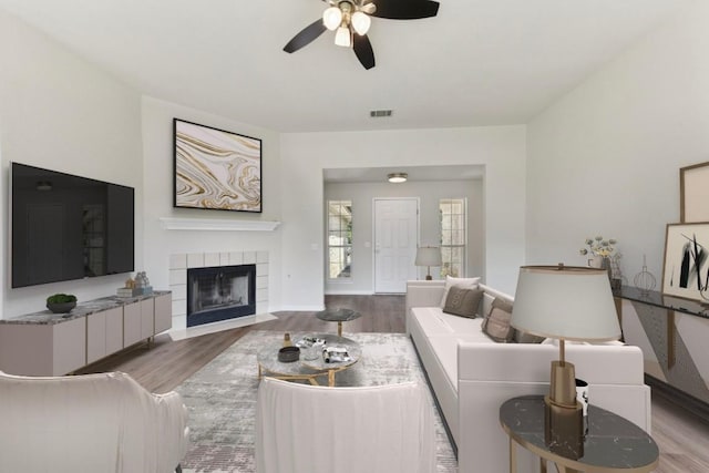 906 Jasmine Trl, Georgetown, TX 78626 - living area with wood finished floors, a ceiling fan, and a tile fireplace