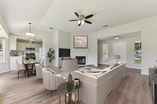906 Jasmine Trl, Georgetown, TX 78626 - living room with a fireplace, light wood finished floors, a ceiling fan, and lofted ceiling