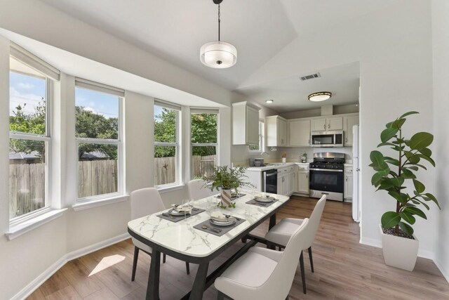 906 Jasmine Trl, Georgetown, TX 78626 - dining area featuring lofted ceiling and light wood finished floors