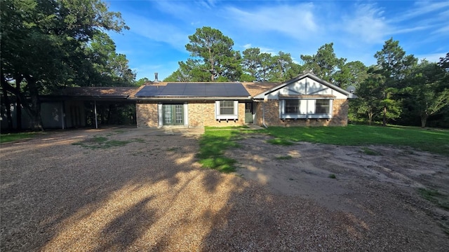 365 Pine Tree Loop, Bastrop, TX 78602 - single story home featuring driveway, roof mounted solar panels, a front lawn, french doors, and a carport