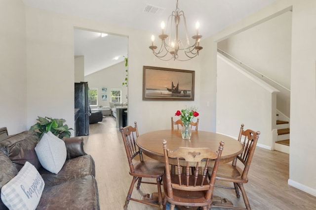 603 Luna Vista Dr, Hutto, TX 78634 - dining room featuring stairway, light wood-type flooring, lofted ceiling, and a chandelier