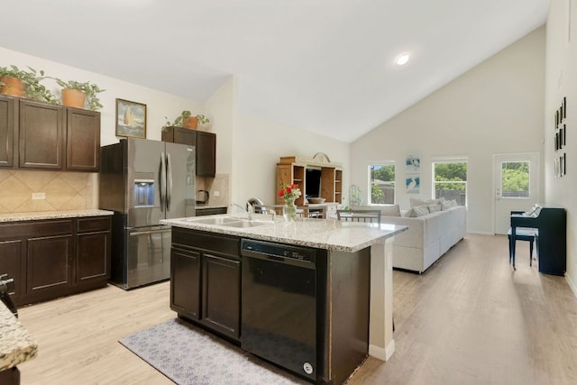 603 Luna Vista Dr, Hutto, TX 78634 - kitchen with black dishwasher, stainless steel refrigerator with ice dispenser, light wood-type flooring, tasteful backsplash, and dark brown cabinets