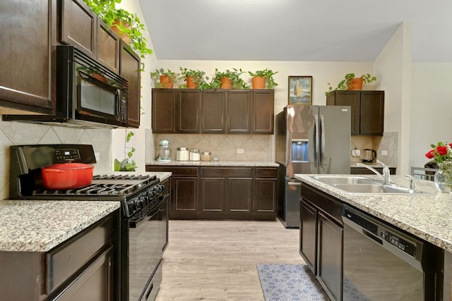 603 Luna Vista Dr, Hutto, TX 78634 - kitchen featuring black appliances, dark brown cabinets, and light wood-type flooring