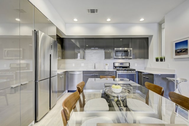 1800 E 4th St Unit 263, Austin, TX 78702 - kitchen with modern cabinets, appliances with stainless steel finishes, gray cabinets, decorative backsplash, and recessed lighting