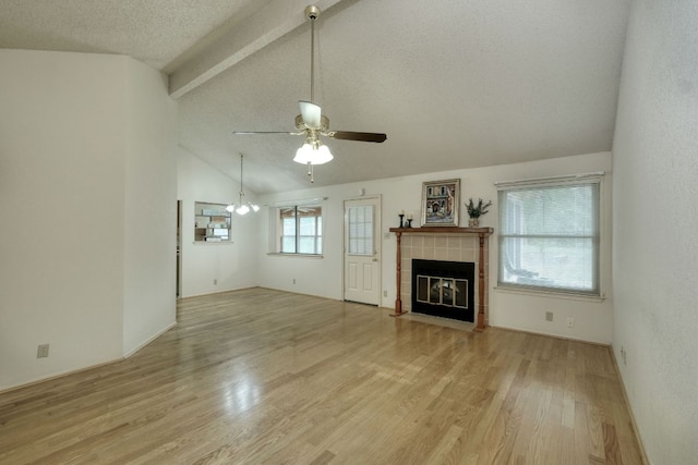 13116 Billiem Dr, Austin, TX 78727 - unfurnished living room featuring a ceiling fan, a tile fireplace, light wood-type flooring, a textured ceiling, and a chandelier