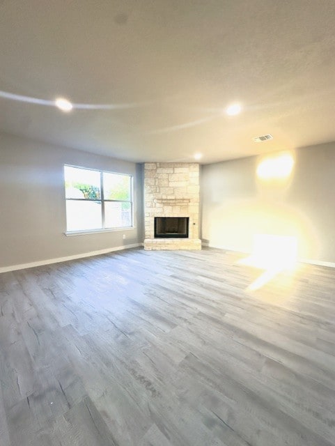 1237 Pelican Pl, New Braunfels, TX 78130 - unfurnished living room featuring wood finished floors, a stone fireplace, and recessed lighting