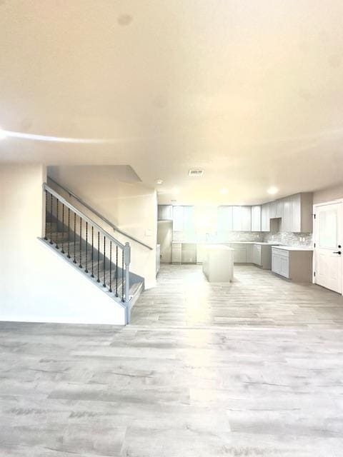 1237 Pelican Pl, New Braunfels, TX 78130 - unfurnished living room featuring light wood finished floors, stairs, and recessed lighting