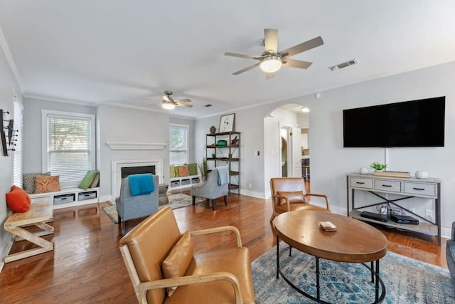 611 W Johanna St, Austin, TX 78704 - living area featuring a ceiling fan, arched walkways, crown molding, wood finished floors, and a fireplace